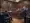 A man in a suit stands in a New Jersey courtroom, facing lawyers and judges seated at desks. The room has a wooden interior with the U.S. flag and official emblems on the wall. Spectators watch from the gallery, as news cameras capture this pivotal moment in state politics.