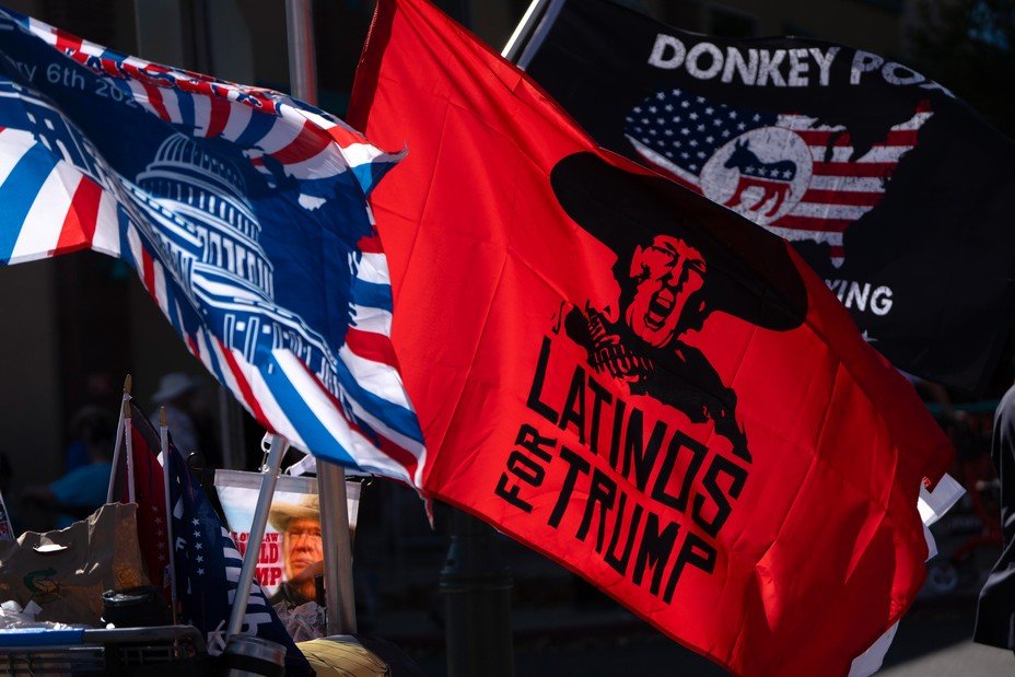 Flags wave in the air, one says 'Latinos for Trump'