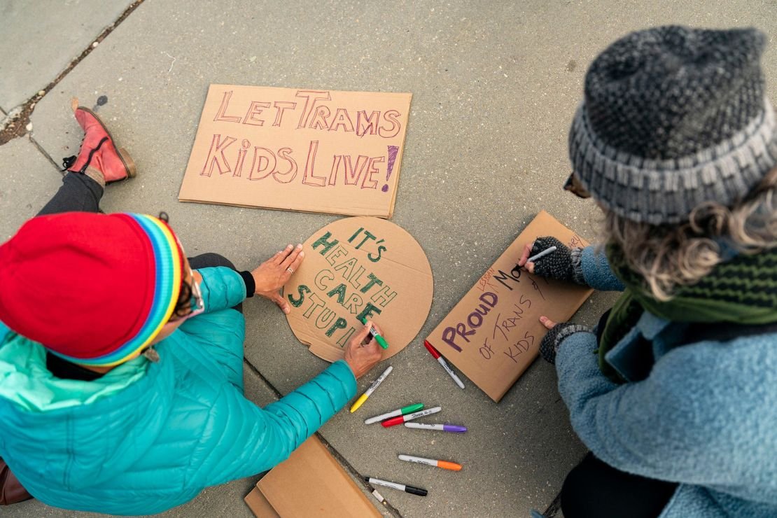 Demonstrators in support of gender-affirming treatment make signs outside the US Supreme Court in Washington, DC, on December 4, 2024.