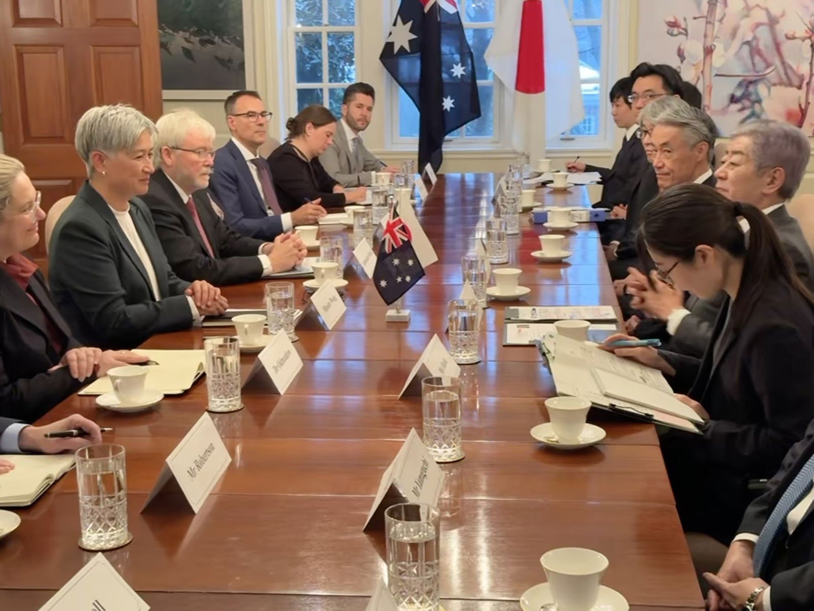 Penny Wong, Kevin Rudd and other sit at a long table across from a Japanese delegation.