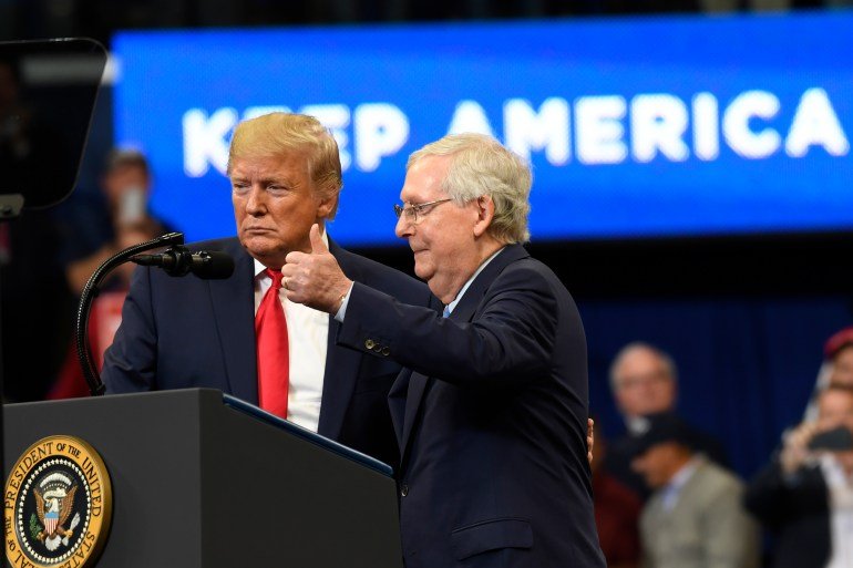 Mitch McConnell appears at a Donald Trump rally, flashing a thumbs-up, in 2019.