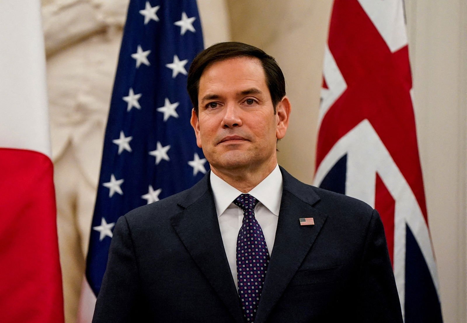 Marco Rubio in front of American flags. 