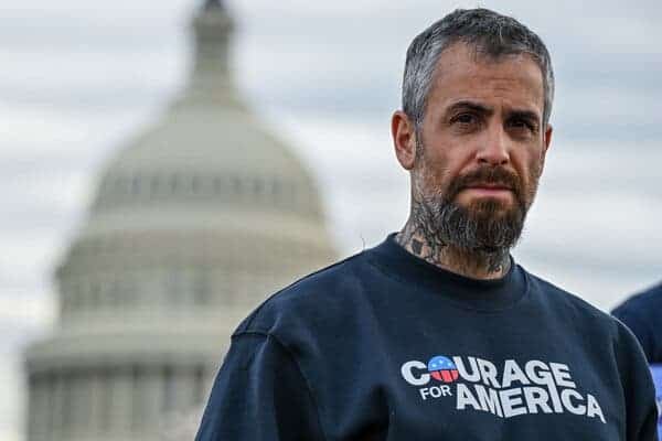 A man in a “Courage for America” sweatshirt, with the Capitol building in the background.
