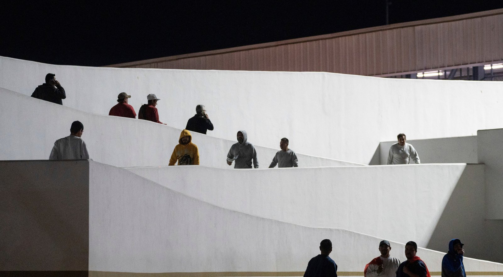 Migrants walking into Mexico after deportation from the U.S. at the El Chaparral border bridge in Tijuana.